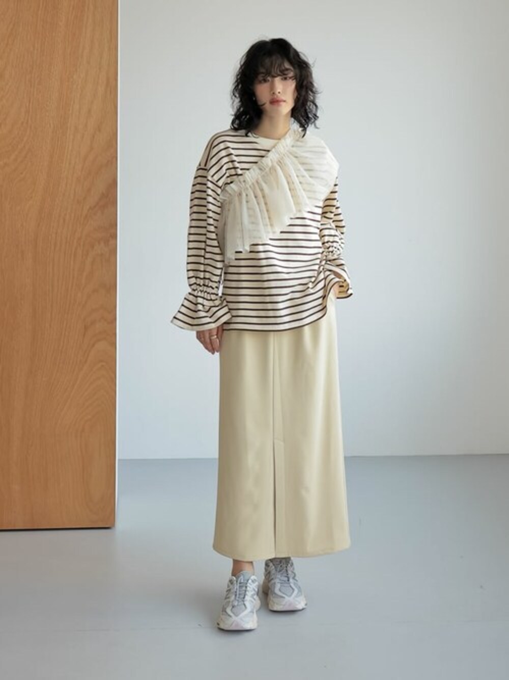 ベージュ系のTシャツ/カットソー、イエロー系のスカート、ホワイト系の付け襟を着用したレディースの春コーディネートの1枚目の写真