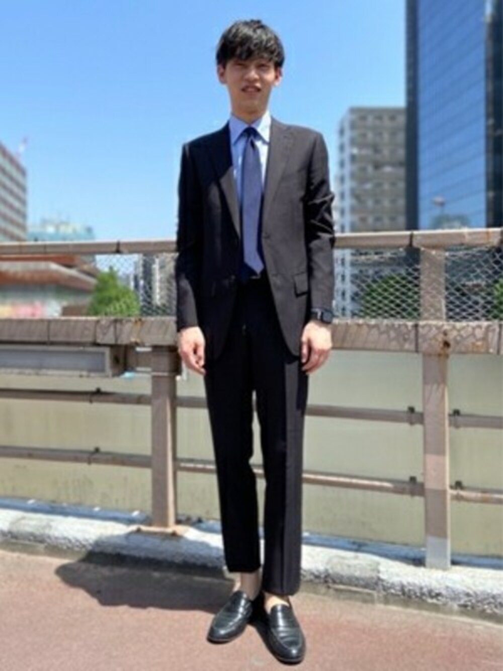 ブラック系のスーツセット、ブルー系のビジネスシャツを着用したメンズの冬コーディネートの1枚目の写真