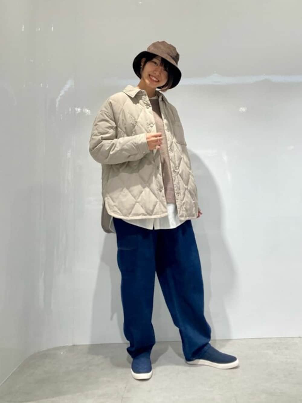 ベージュ系のダウンジャケット/コート、ブラウン系のニット/セーター、ホワイト系のシャツ/ブラウスを着用したレディースの秋コーディネートの1枚目の写真