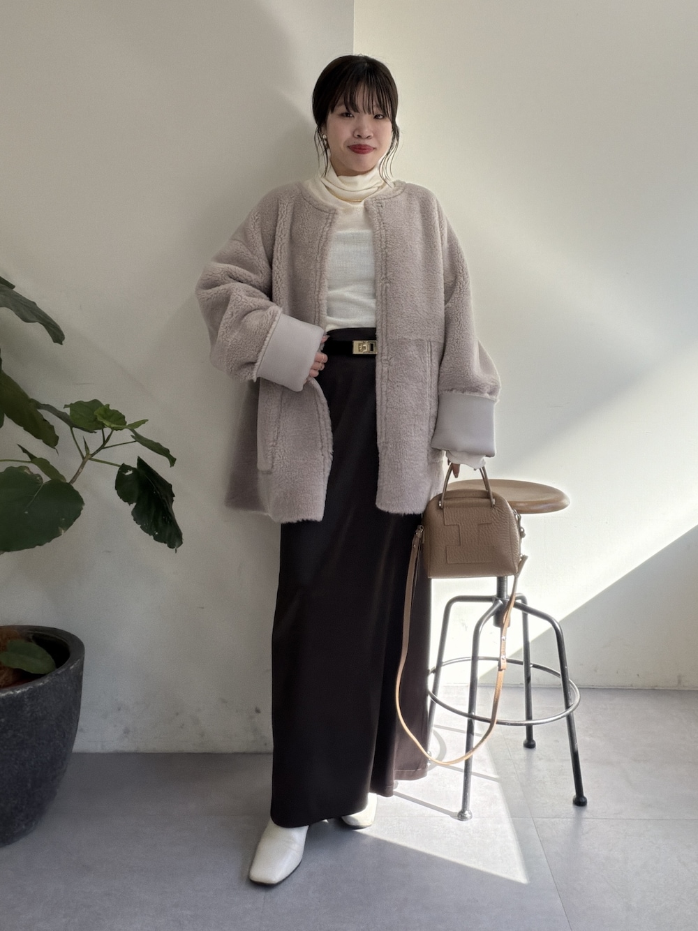 グレー系のその他アウター、ブラウン系のスカート、ホワイト系のTシャツ/カットソーを着用したレディースの秋コーディネートの1枚目の写真