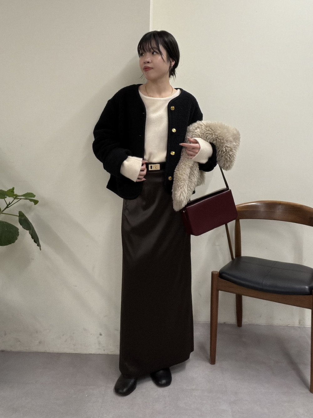 ホワイト系のニット/セーター、ブラック系のベスト、ブラウン系のスカートを着用したレディースの秋コーディネートの1枚目の写真