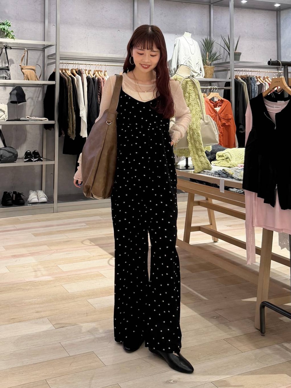 ブラウン系のショルダーバッグ、ブラック系のパンプス、ブラック系のサロペット/オーバーオールを着用したレディースの春コーディネートの1枚目の写真