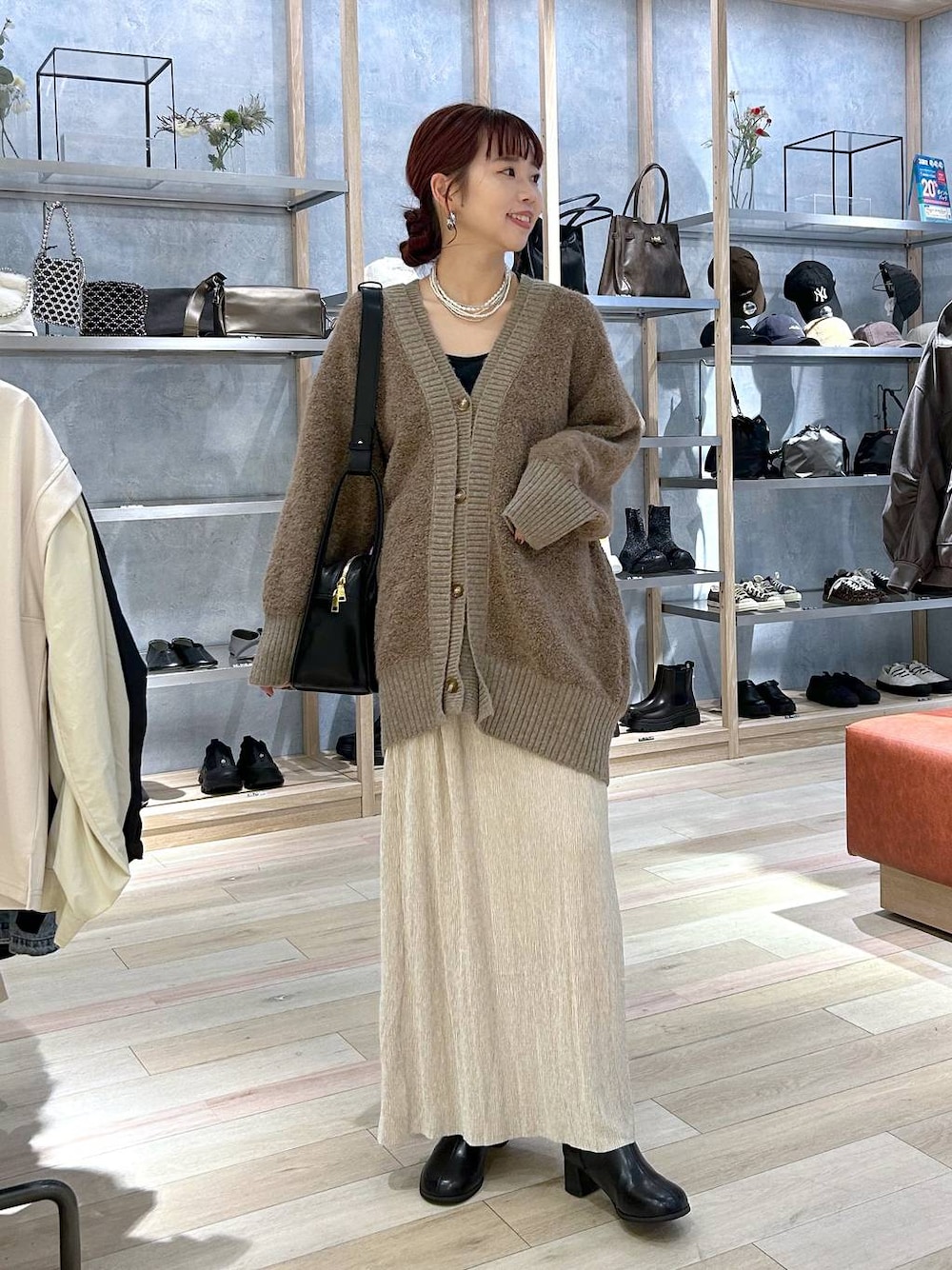 ブラウン系のカーディガン/ボレロ、ブラック系のブーツ、ブラック系のショルダーバッグを着用したレディースの秋コーディネートの1枚目の写真