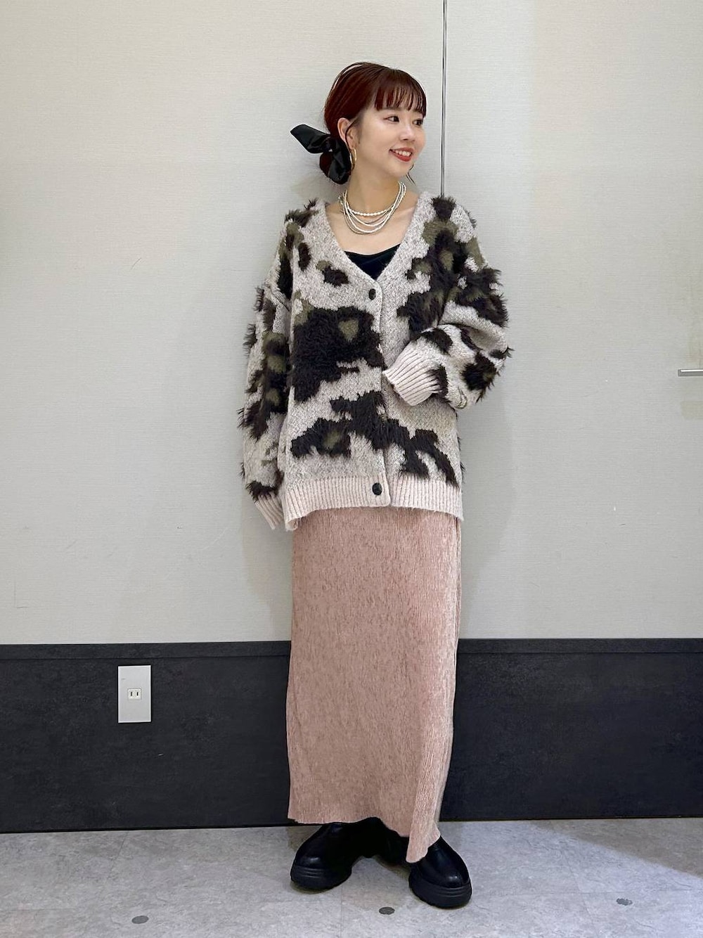 ブラック系のブーツ、ピンク系のスカート、ベージュ系のカーディガン/ボレロを着用したレディースの秋コーディネートの1枚目の写真