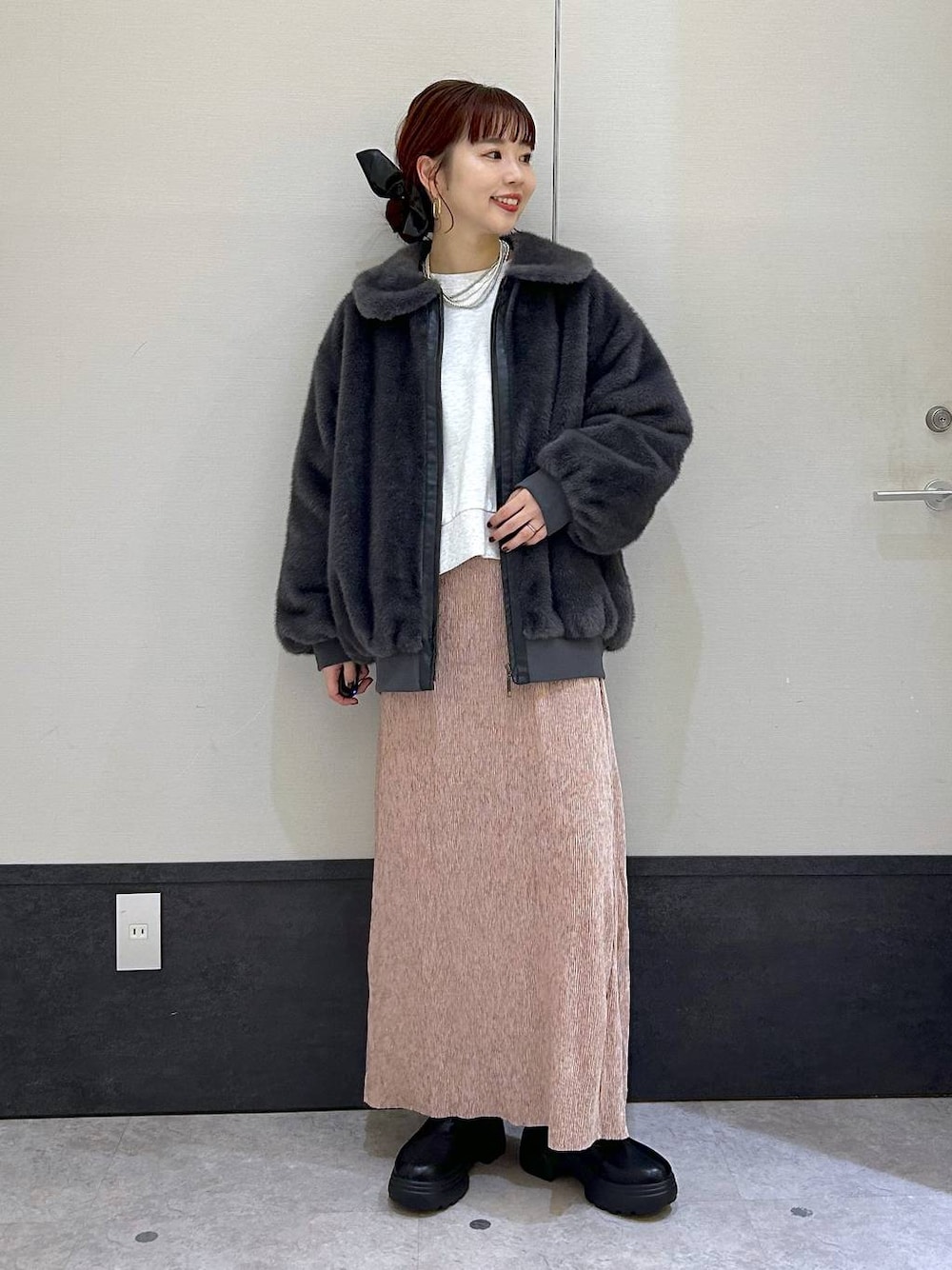 グレー系のブルゾン、グレー系のTシャツ/カットソー、ブラック系のブーツを着用したレディースの秋コーディネートの1枚目の写真