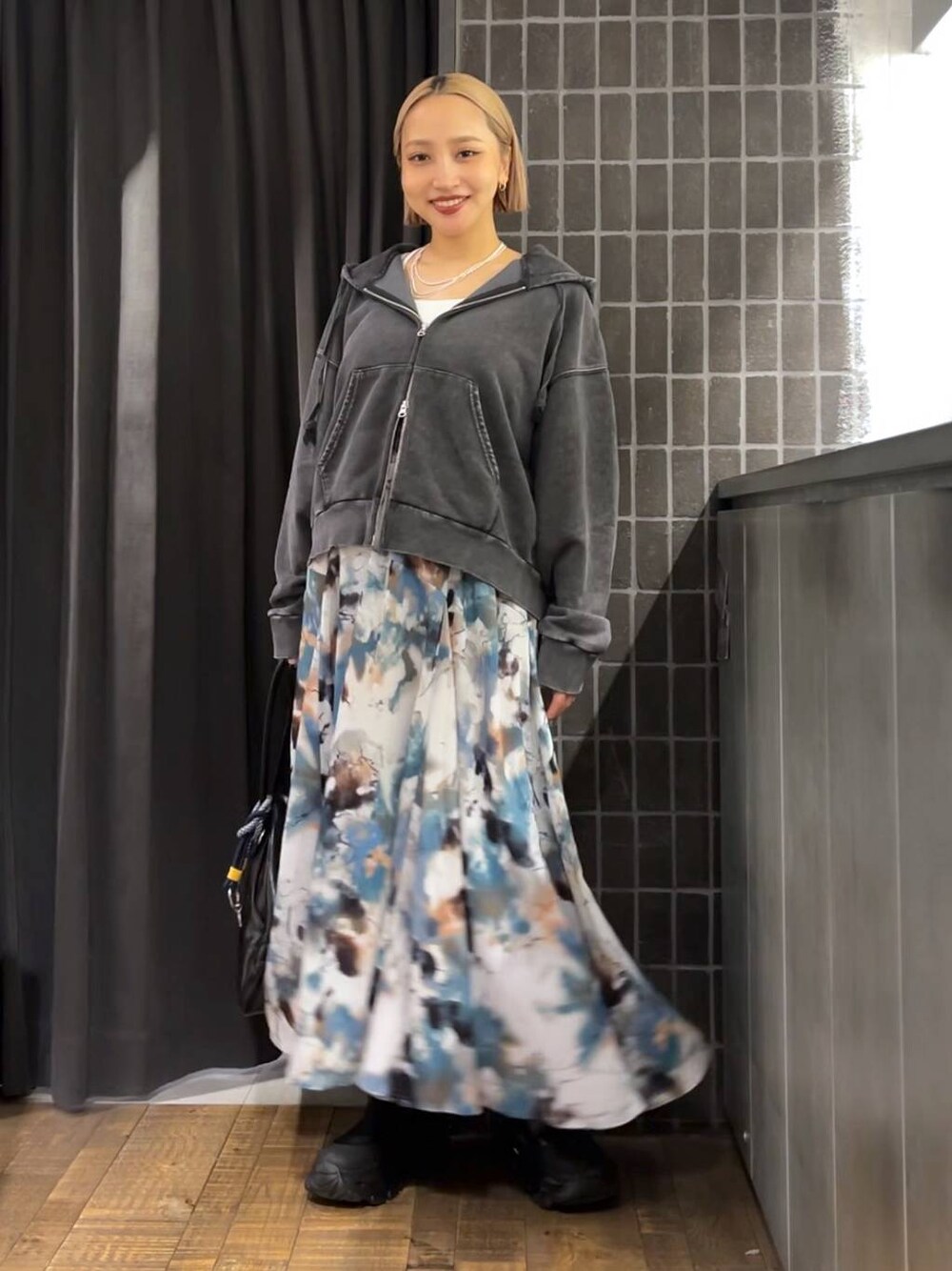 ブラック系のパーカー、ブラック系のボストンバッグ、ブラック系のブーツを着用したレディースの夏コーディネートの1枚目の写真