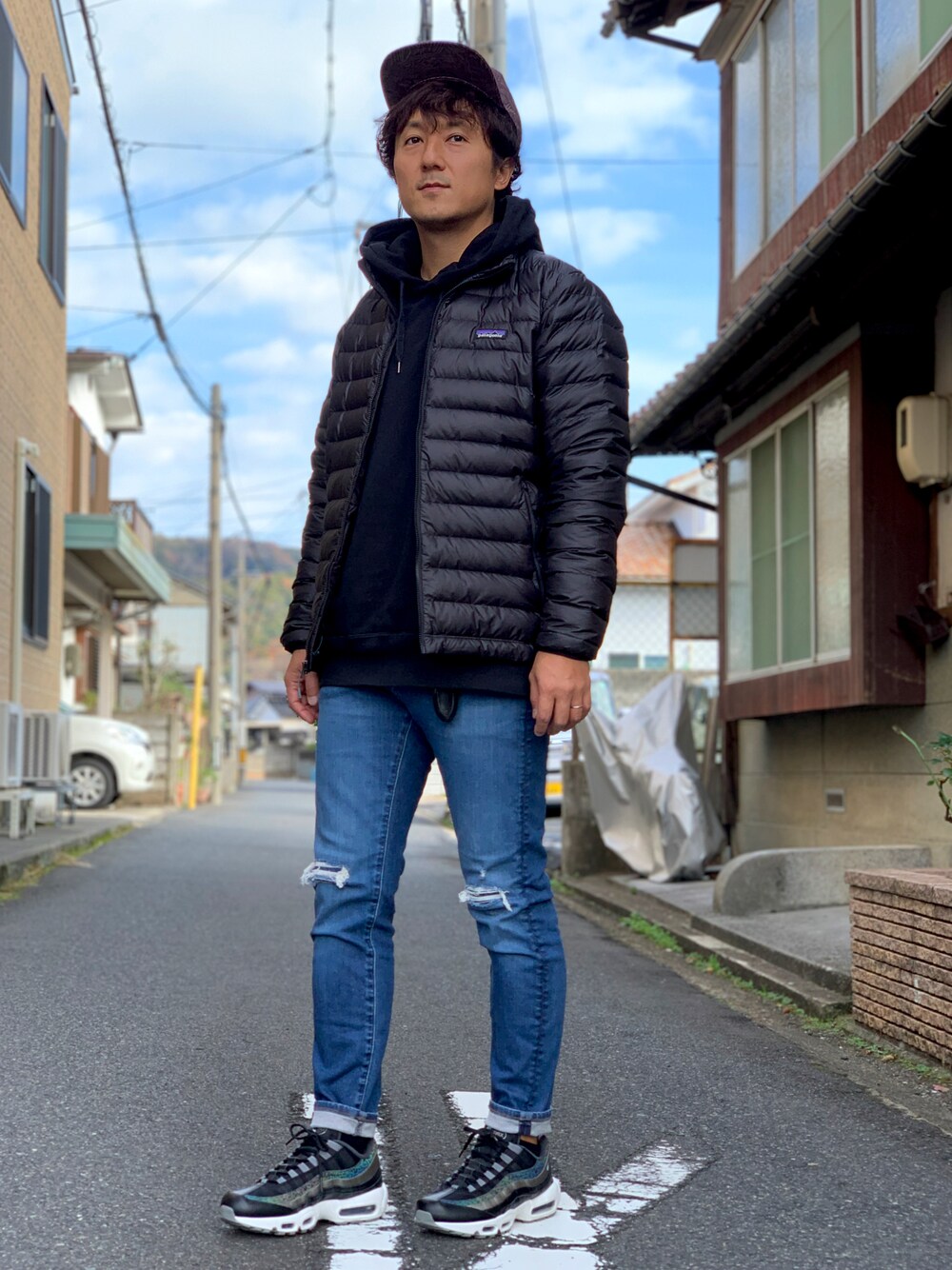 「冬のコーデ、オトナカジュアル、休日コーデ、スニーカー、ダウンジャケット、patagonia、キャップ、エアマックス95、ブラック、ダメージデニムパンツ」｜「UNIQLOのアイテム（デニムパンツ、ブルー系）」を使った、yosukeさん（メンズ・171cm）の冬コーディネートの1枚目の写真