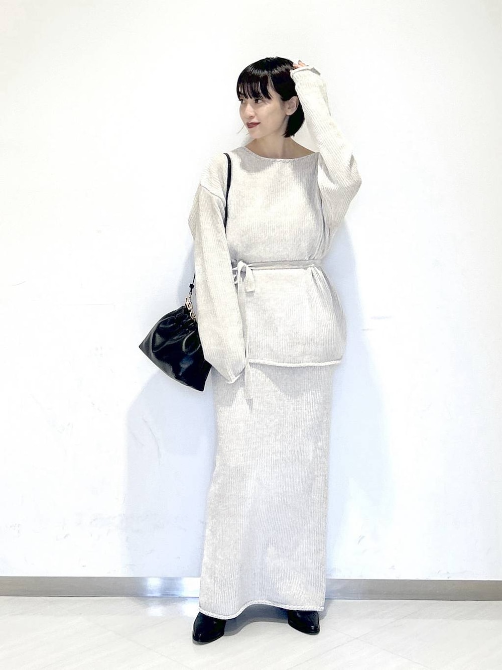 ブラック系のブーツ、ベージュ系のセットアップ、ブラック系のショルダーバッグを着用したレディースの冬コーディネートの1枚目の写真