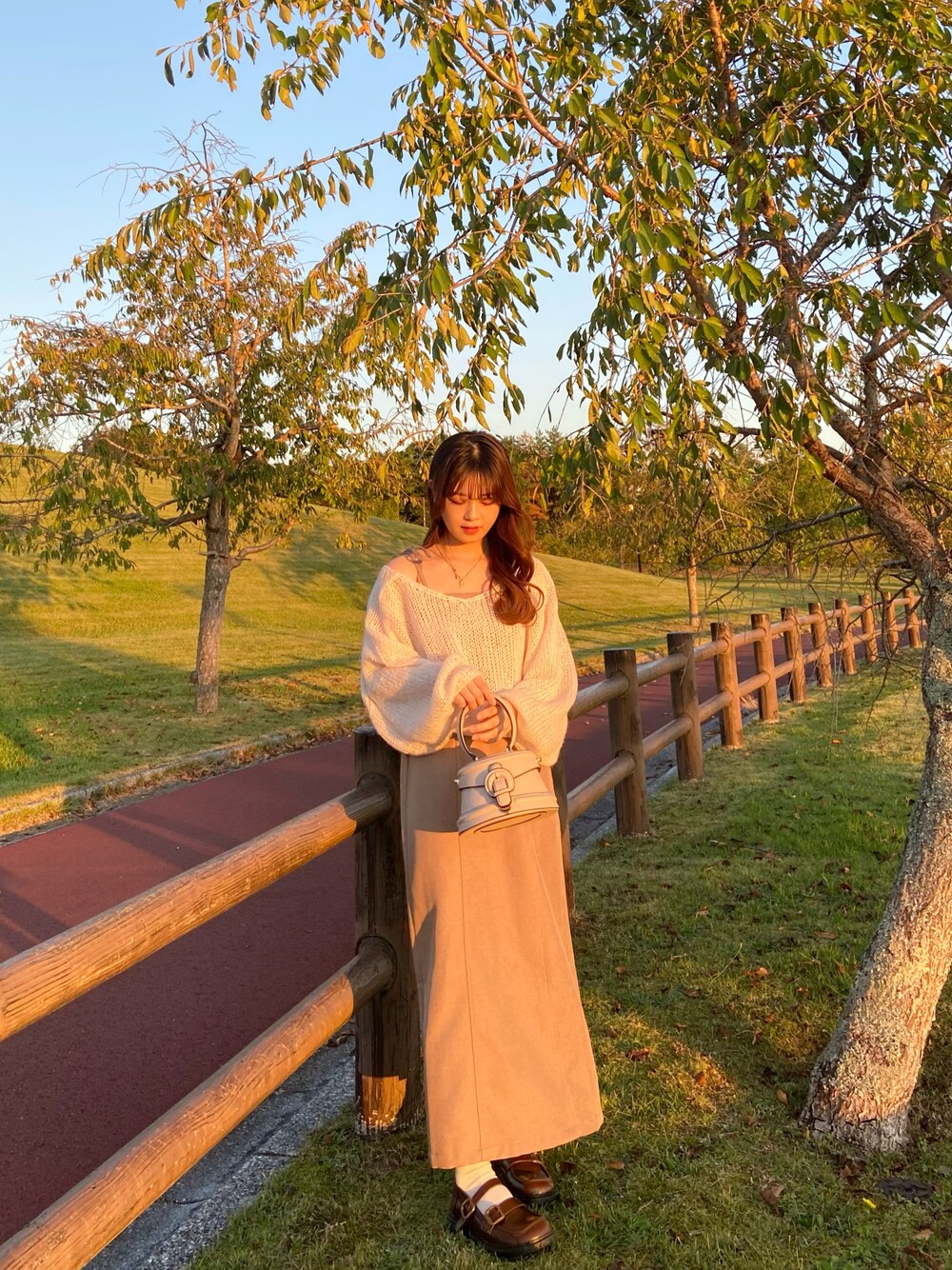 ブラウン系のワンピース、ベージュ系のニット/セーター、ブラウン系のローファーを着用したレディースの秋コーディネートの1枚目の写真