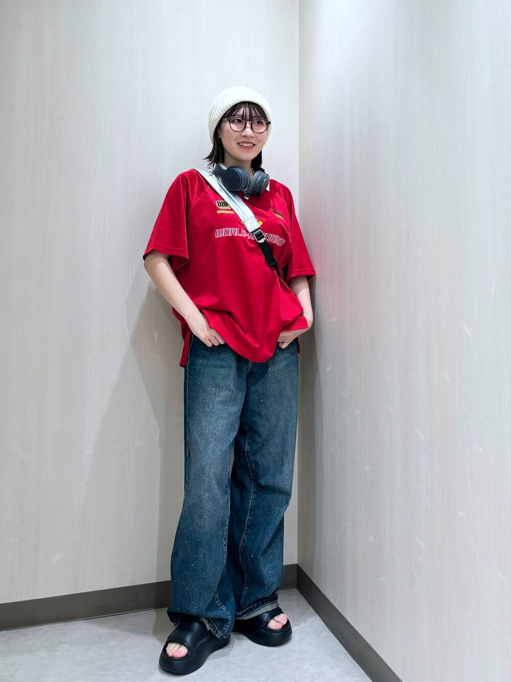 ブルー系のデニムパンツ、シルバー系のショルダーバッグ、レッド系のTシャツ/カットソーを着用したレディースの夏コーディネートの1枚目の写真