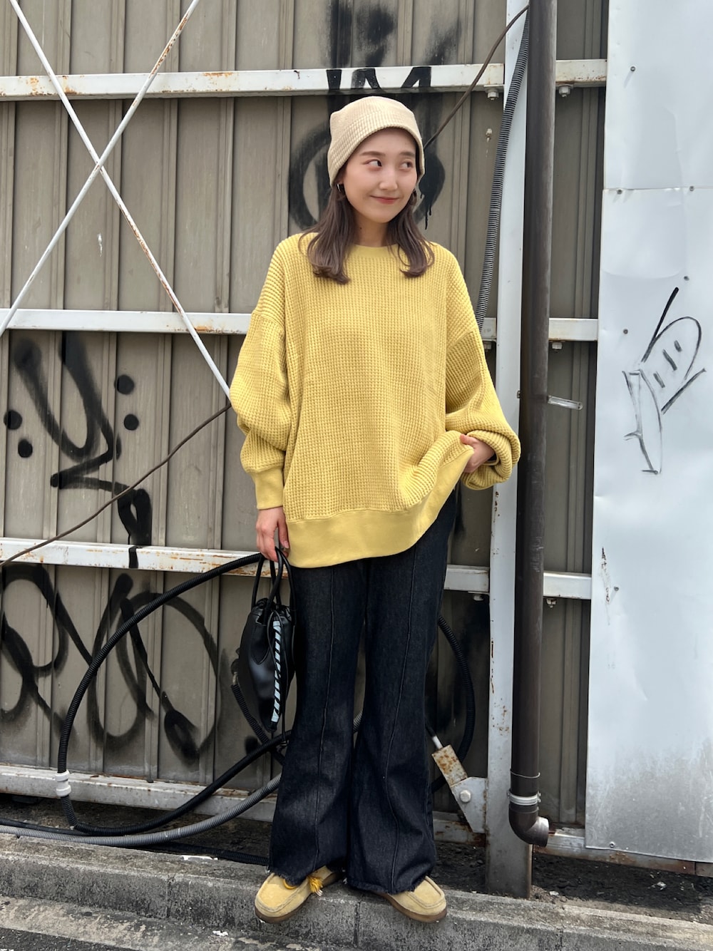 ブラック系のTシャツ/カットソー、ブラック系のショルダーバッグ、ブラック系のデニムパンツを着用したレディースの秋コーディネートの1枚目の写真