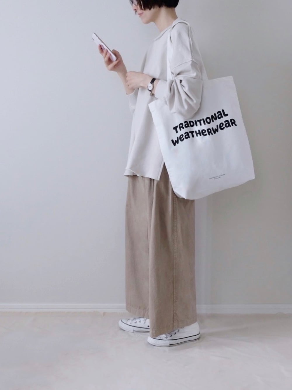 ベージュ系のその他パンツ、ホワイト系のスニーカー、ホワイト系のトートバッグを着用したレディースの秋コーディネートの1枚目の写真