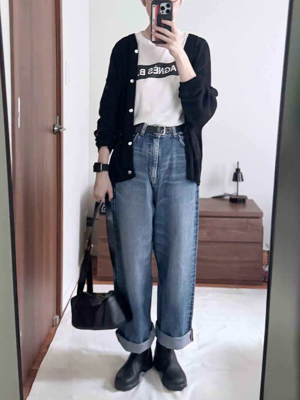 ホワイト系のTシャツ/カットソー、ブラック系のショルダーバッグ、ブラック系のカーディガン/ボレロを着用したレディースの秋コーディネートの1枚目の写真