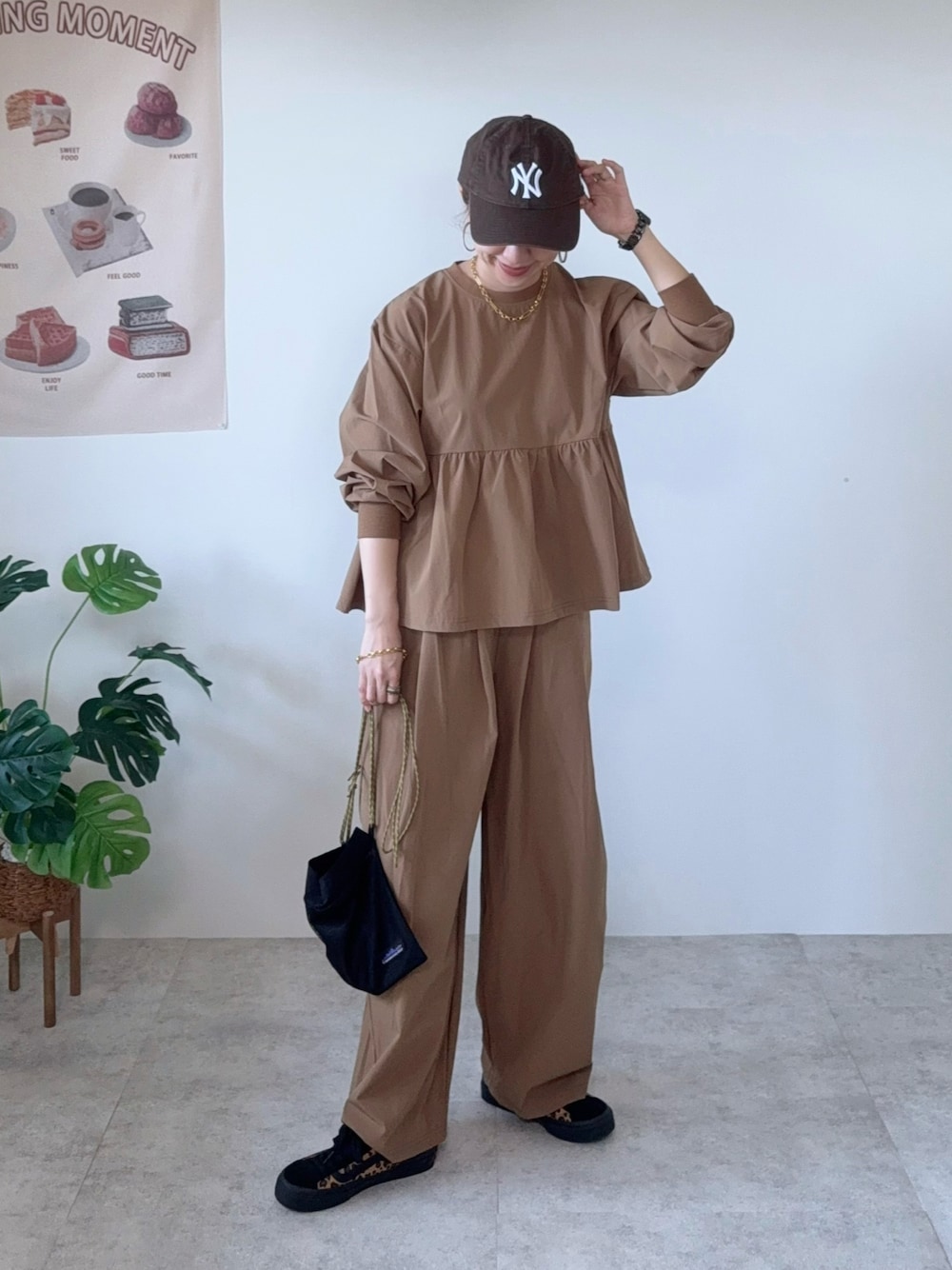 イエロー系のその他パンツ、ブラウン系のシューズ、ブラウン系のキャップを着用したレディースの夏コーディネートの1枚目の写真