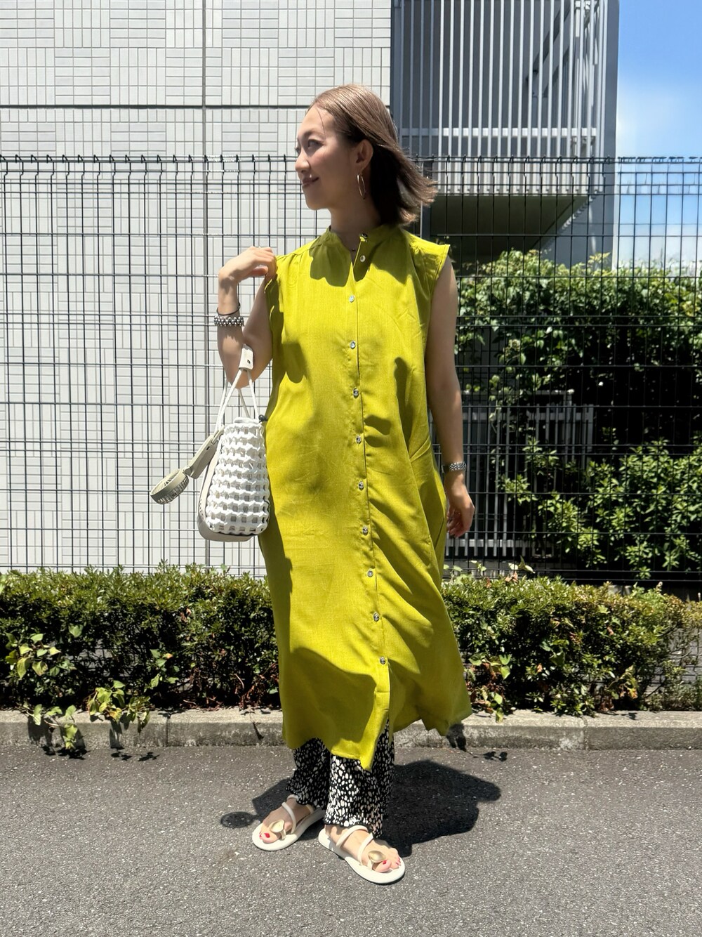 グリーン系のワンピース、ホワイト系のサンダル、ブラック系のその他パンツを着用したレディースの夏コーディネートの1枚目の写真
