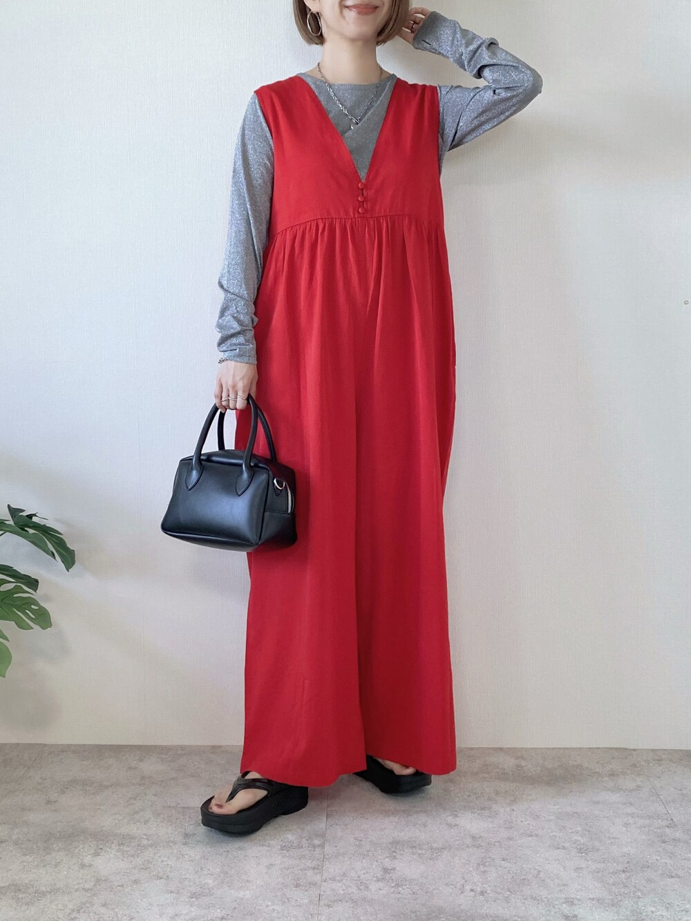 ブラック系のバッグ、レッド系のつなぎ/オールインワン、グレー系のTシャツ/カットソーを着用したレディースの春コーディネートの1枚目の写真