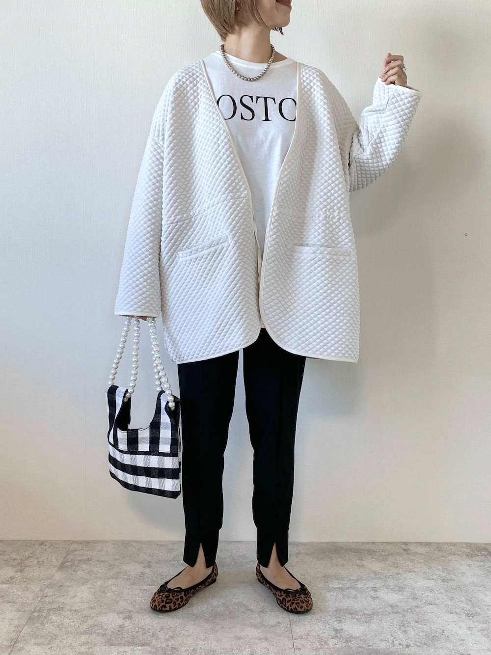 ホワイト系のTシャツ/カットソー、ブラック系のパンツ、ホワイト系のショルダーバッグを着用したレディースの秋コーディネートの1枚目の写真