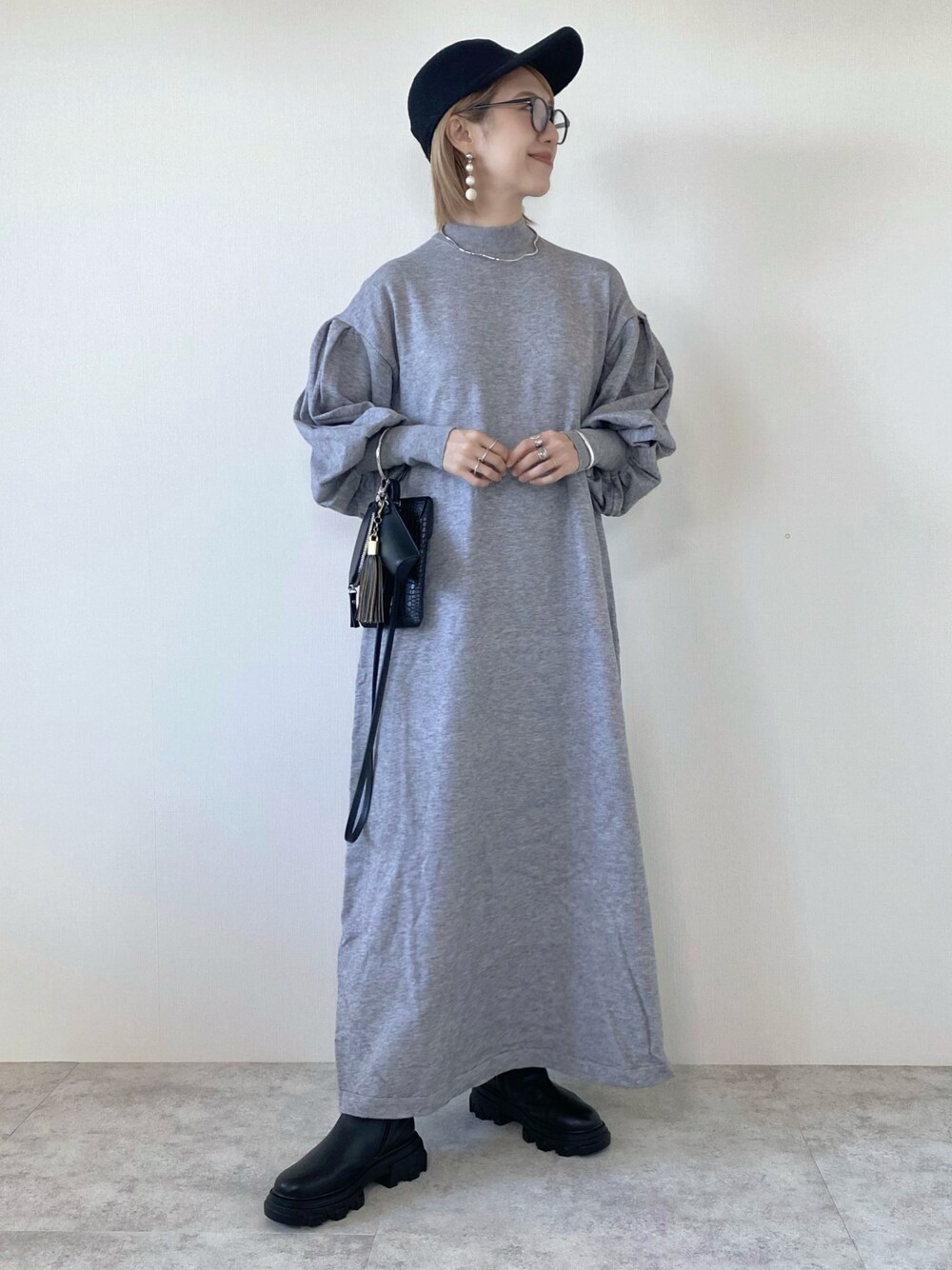 グレー系のワンピース、シルバー系のネックレスを着用したレディースの秋コーディネートの1枚目の写真