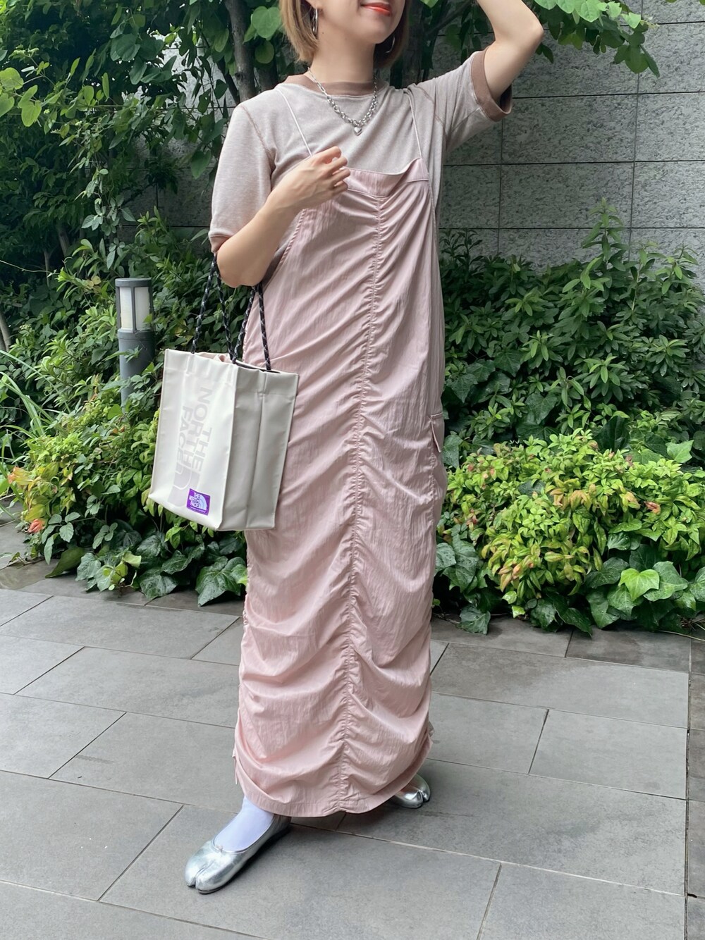 ピンク系のワンピース、ブラウン系のTシャツ/カットソー、シルバー系のバレエシューズを着用したレディースの夏コーディネートの1枚目の写真