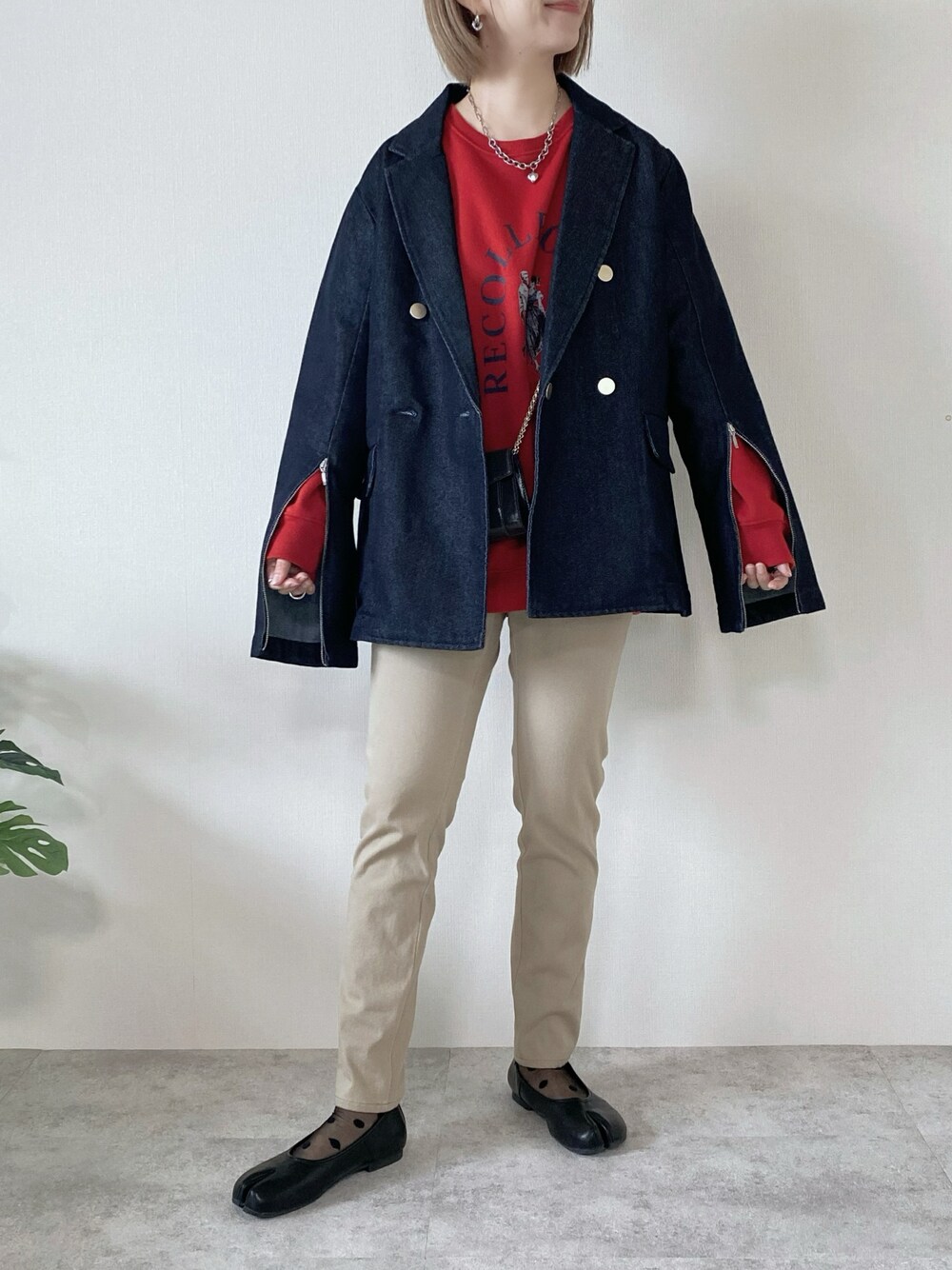 レッド系のスウェット、ブルー系のデニムジャケット、ブラック系のパンプスを着用したレディースの春コーディネートの1枚目の写真
