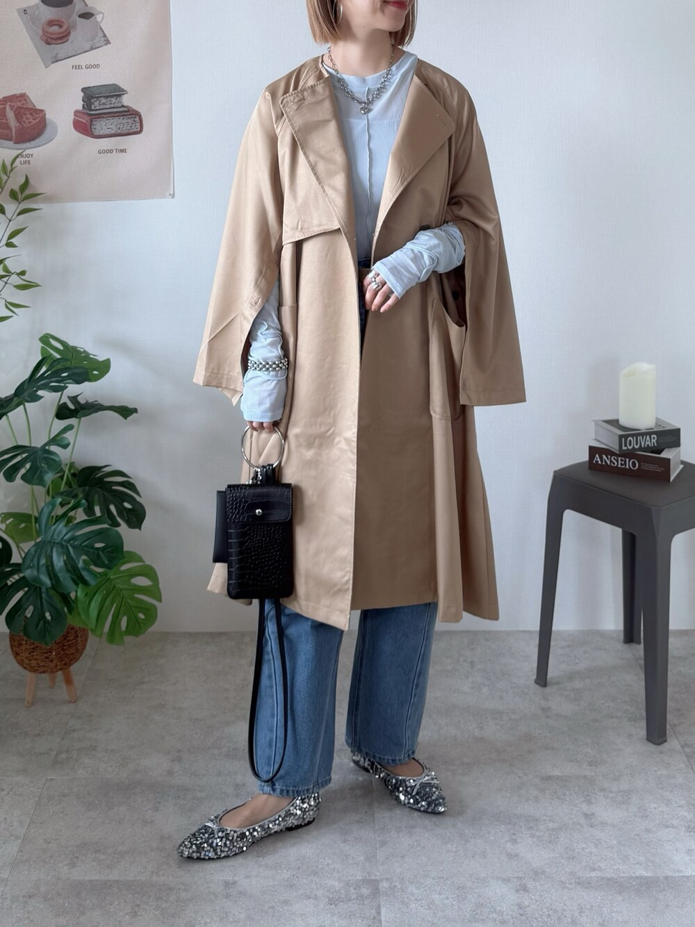 ベージュ系のノーカラーコート、ブルー系のTシャツ/カットソー、シルバー系のパンプスを着用したレディースの春コーディネートの1枚目の写真
