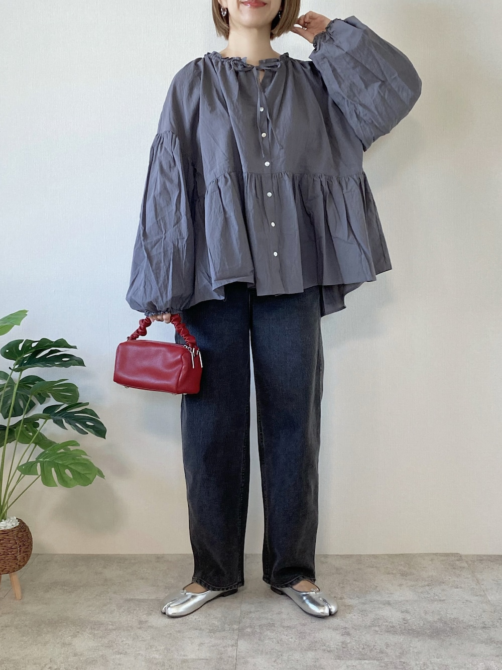グレー系のシャツ/ブラウス、ブラック系のデニムパンツ、レッド系のボストンバッグを着用したレディースの春コーディネートの1枚目の写真