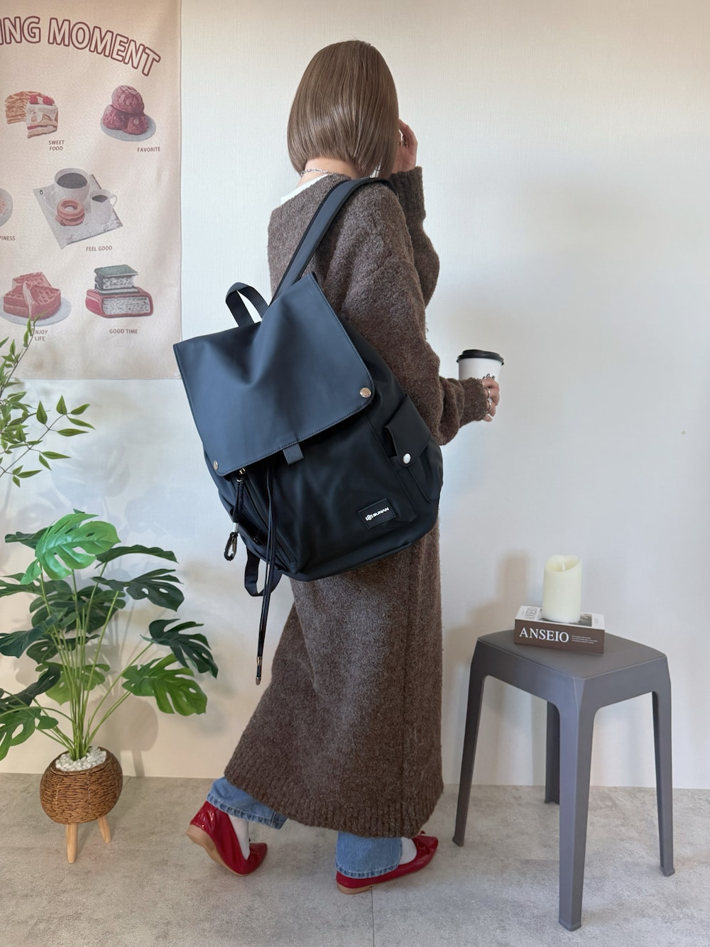 ブラック系のバックパック/リュック、ブラウン系のワンピース、レッド系のバレエシューズを着用したレディースの冬コーディネートの1枚目の写真