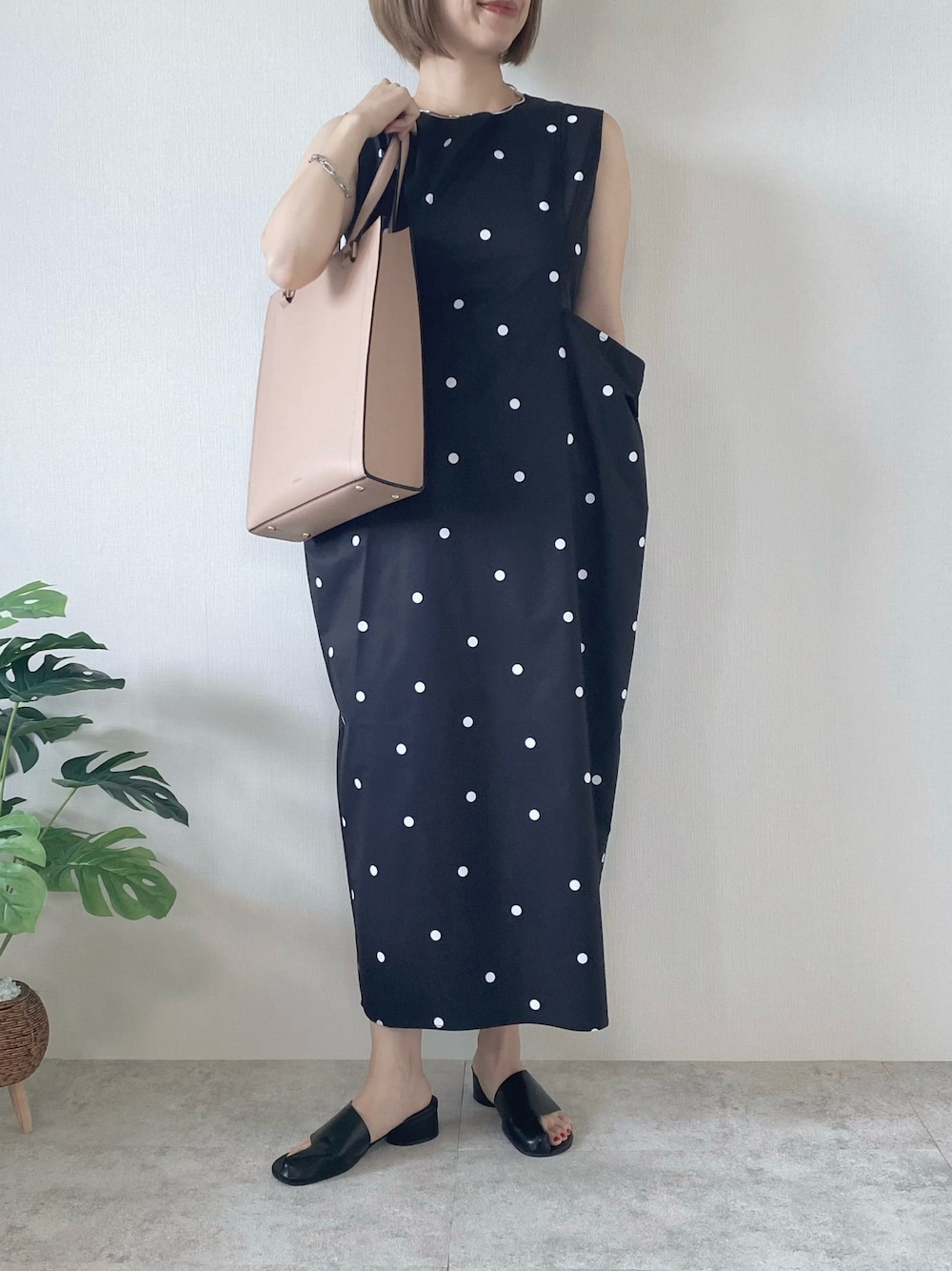 ブラック系のサンダル、ブラック系のワンピース、ピンク系のトートバッグを着用したレディースの夏コーディネートの1枚目の写真