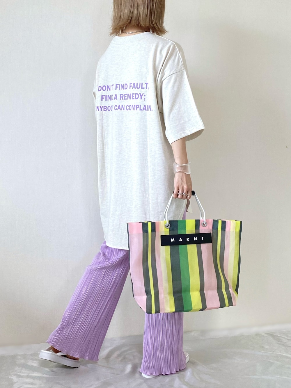 ベージュ系のTシャツ/カットソー、グリーン系のトートバッグ、パープル系のセットアップを着用したレディースの春コーディネートの1枚目の写真