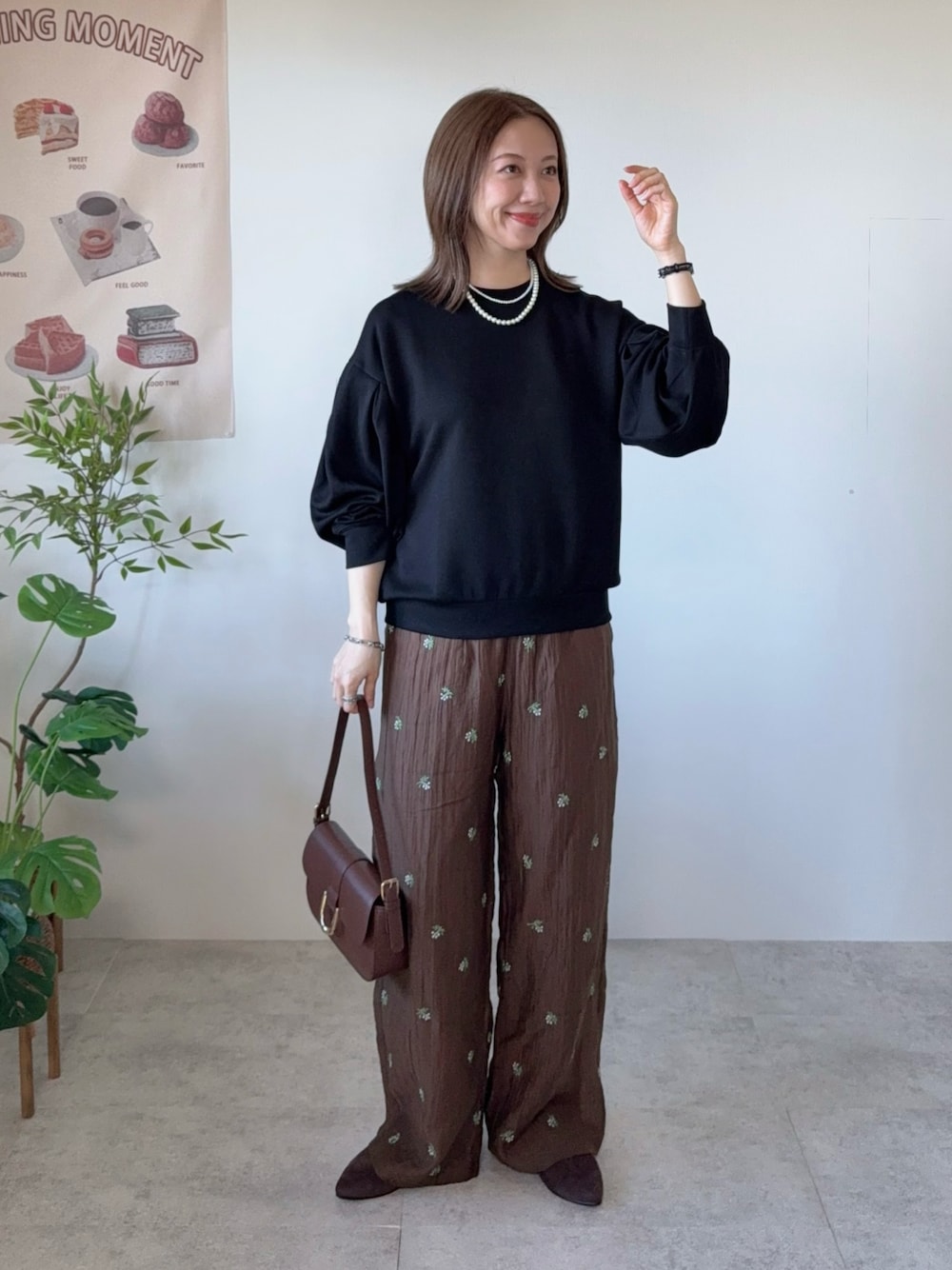 ブラック系のTシャツ/カットソー、ブラウン系のその他パンツ、ブラウン系のハンドバッグを着用したレディースの春コーディネートの1枚目の写真