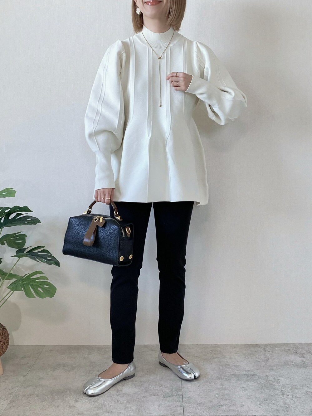 ホワイト系のその他トップス、ブラック系のボストンバッグ、シルバー系のバレエシューズを着用したレディースの冬コーディネートの1枚目の写真