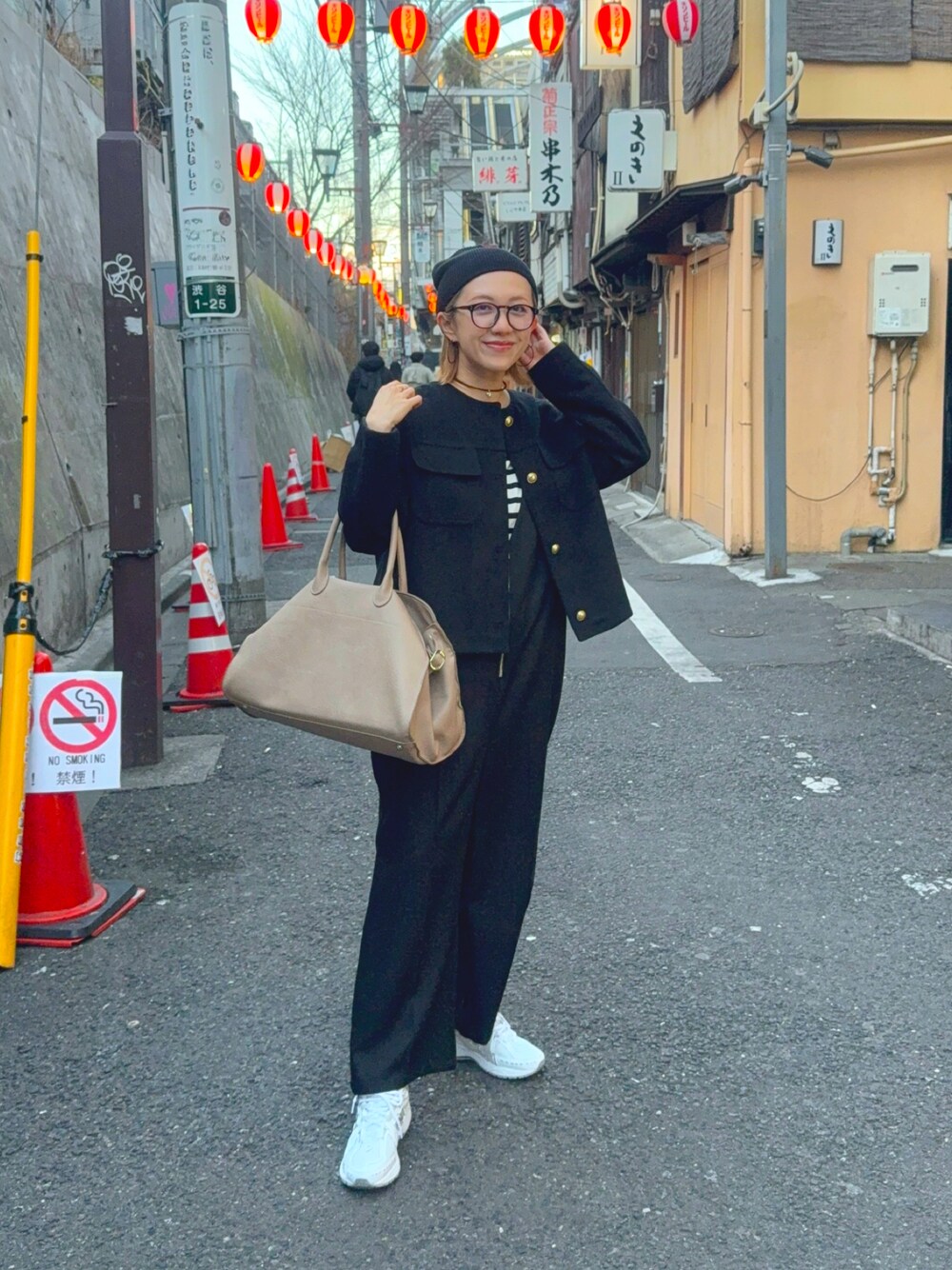 ホワイト系のスニーカー、ブラック系のジャケット/アウター、ベージュ系のボストンバッグを着用したレディースの春コーディネートの1枚目の写真