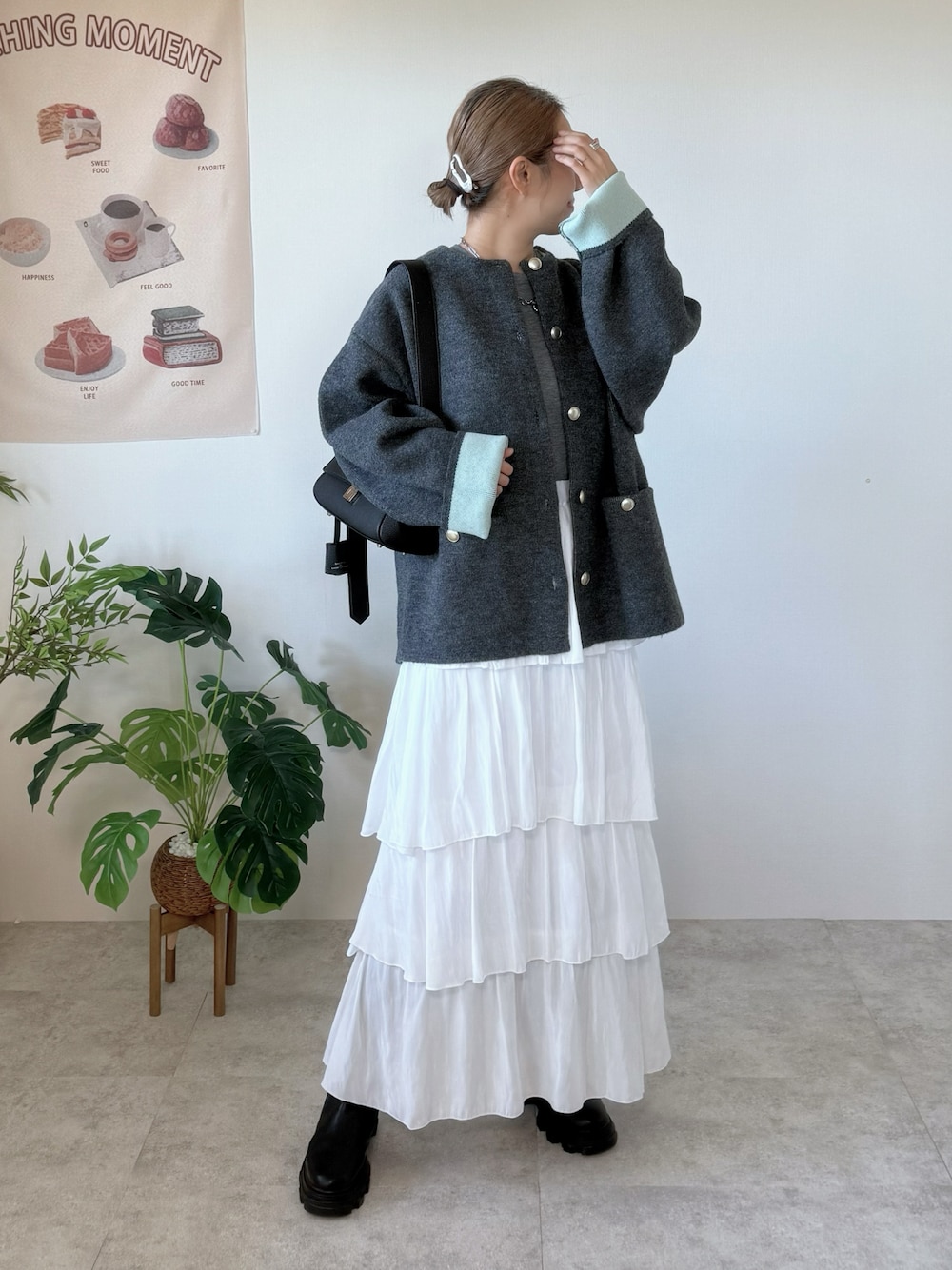 グレー系のカーディガン/ボレロ、ホワイト系のスカート、ブラック系のショルダーバッグを着用したレディースの秋コーディネートの1枚目の写真