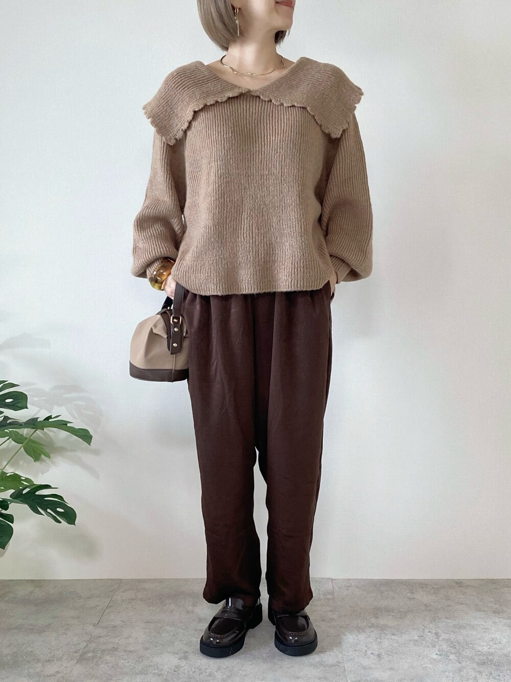 ブラウン系のその他パンツ、ブラウン系のローファー、ブラウン系のハンドバッグを着用したレディースの秋コーディネートの1枚目の写真