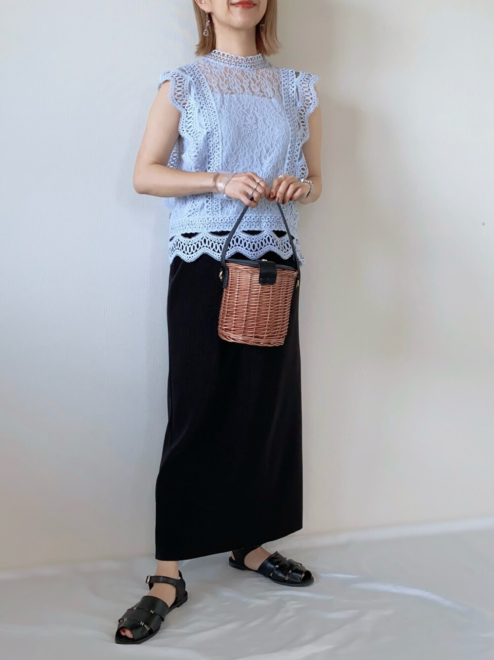 ブルー系のシャツ/ブラウス、ブラック系のバッグ、ブラック系のスカートを着用したレディースの春コーディネートの1枚目の写真