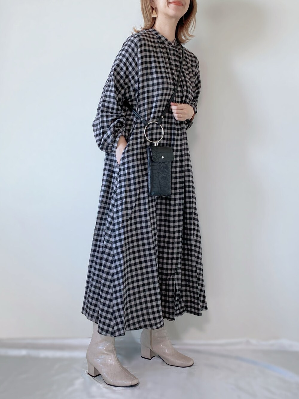 その他のシャツワンピース、ブラック系のショルダーバッグ、ホワイト系のブーツを着用したレディースの冬コーディネートの1枚目の写真