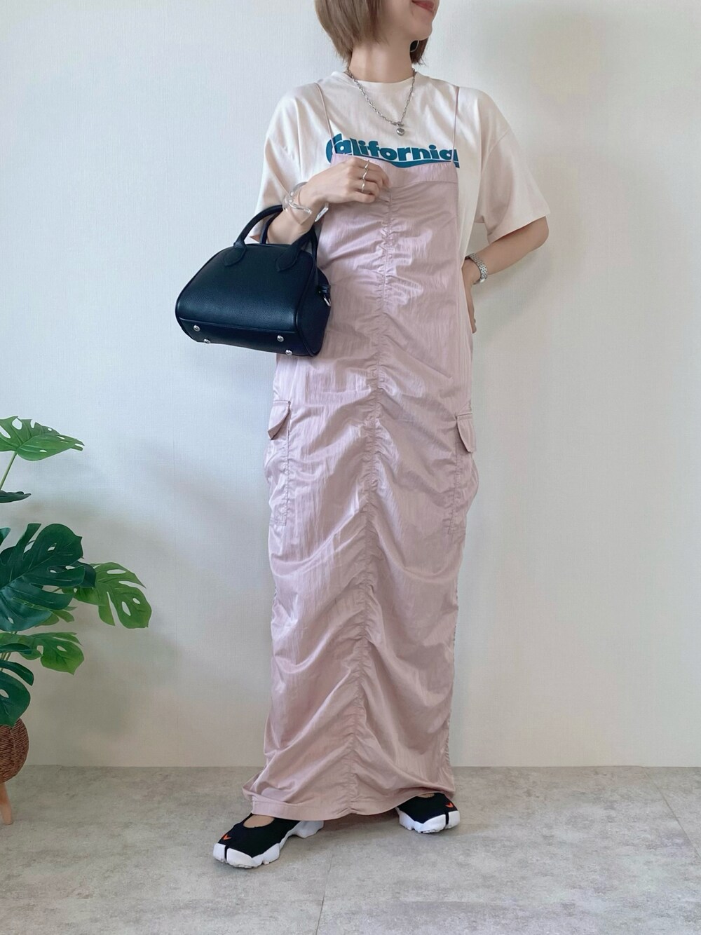 ブラック系のボストンバッグ、ピンク系のワンピース、ベージュ系のTシャツ/カットソーを着用したレディースの夏コーディネートの1枚目の写真