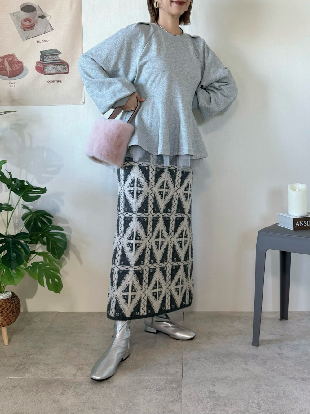 グレー系のスカート、グレー系のスウェット、シルバー系のブーツを着用したレディースの冬コーディネートの1枚目の写真