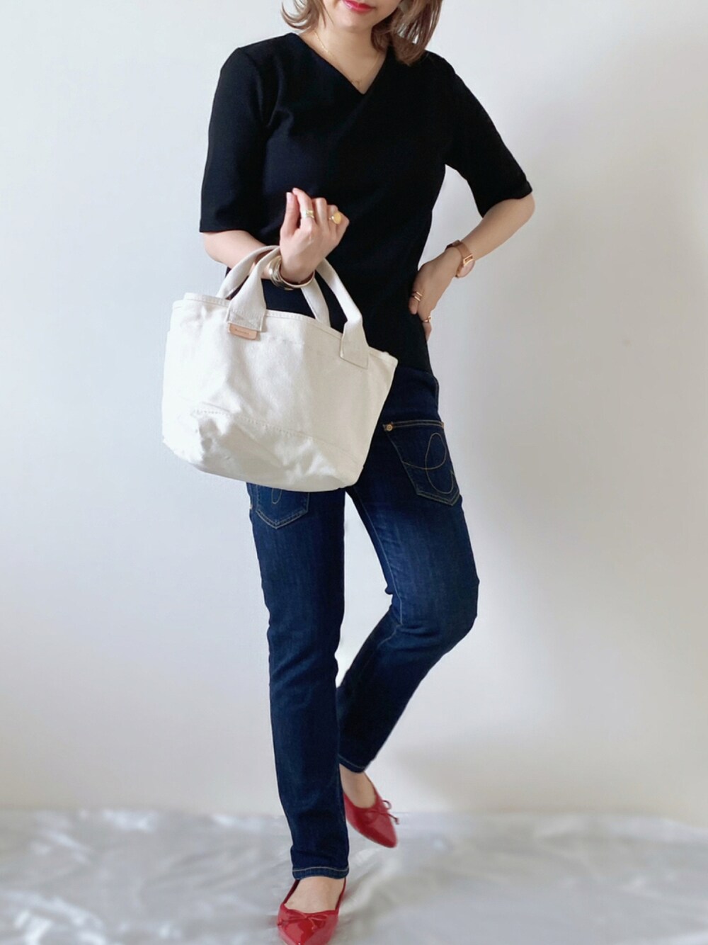 レッド系のバレエシューズ、ホワイト系のトートバッグ、ブラック系のTシャツ/カットソーを着用したレディースの夏コーディネートの1枚目の写真