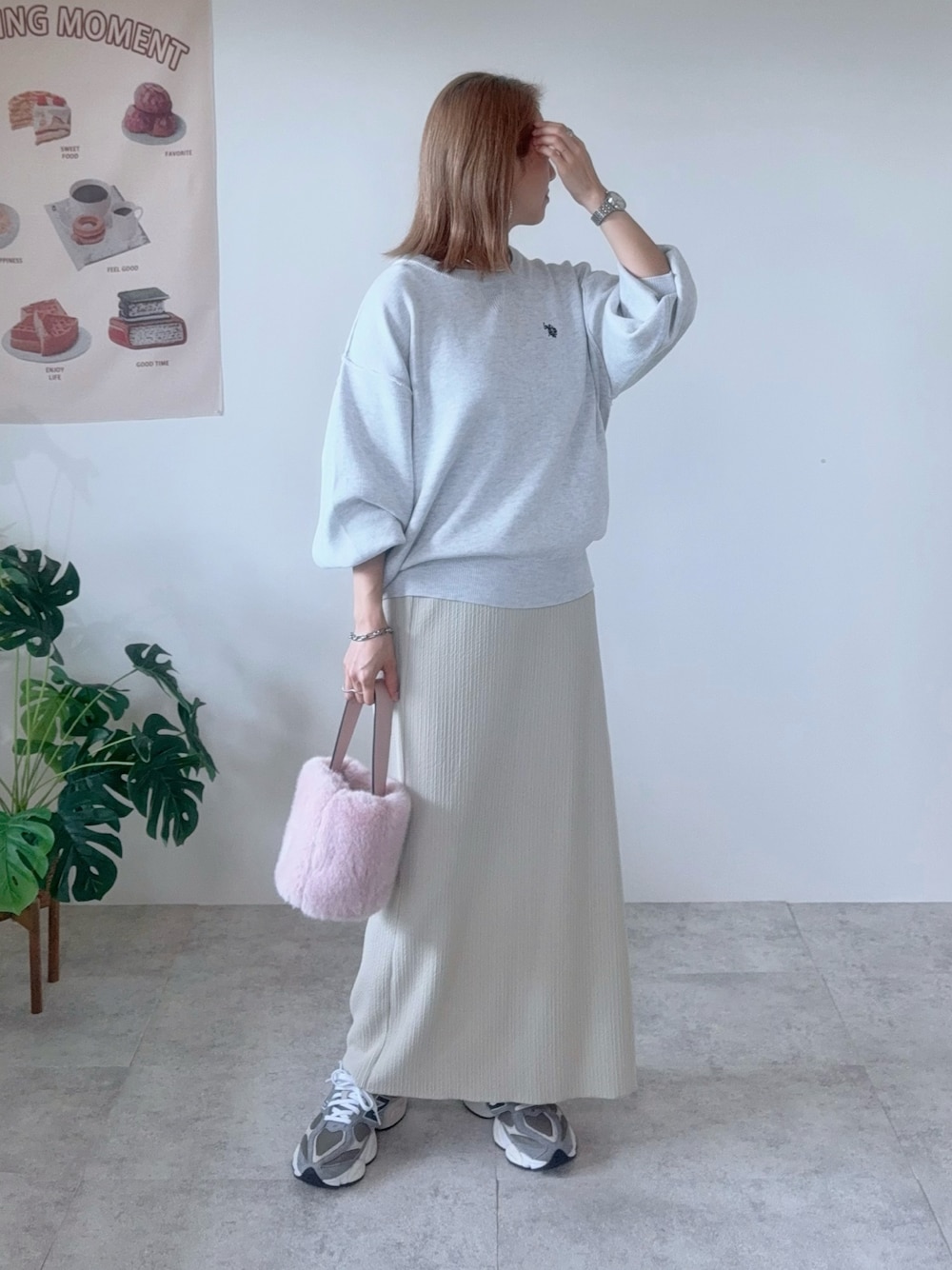 ベージュ系のニット/セーター、ベージュ系のスカート、グレー系のスニーカーを着用したレディースの秋コーディネートの1枚目の写真