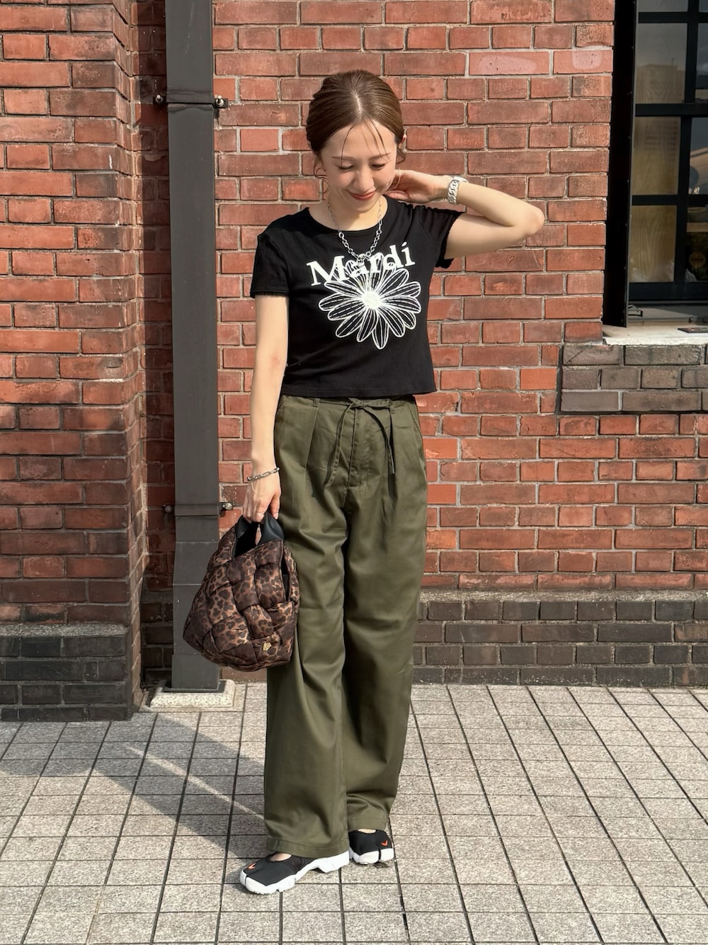 ブラック系のTシャツ/カットソー、グリーン系のチノパンツ、その他のショルダーバッグを着用したレディースの夏コーディネートの1枚目の写真