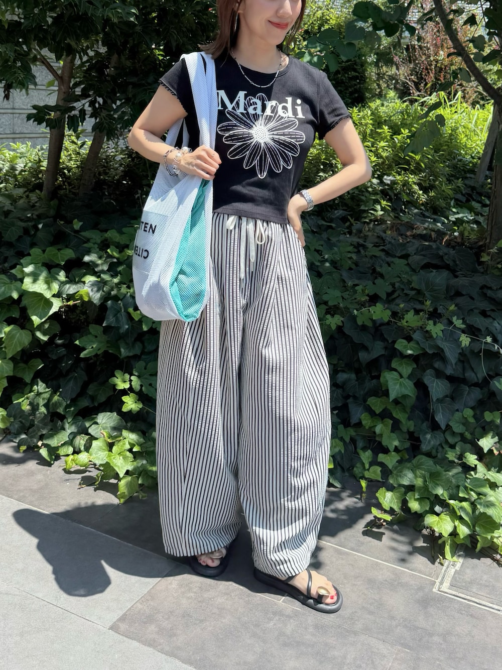 ホワイト系のその他パンツ、ブラック系のTシャツ/カットソー、ホワイト系のトートバッグを着用したレディースの夏コーディネートの1枚目の写真