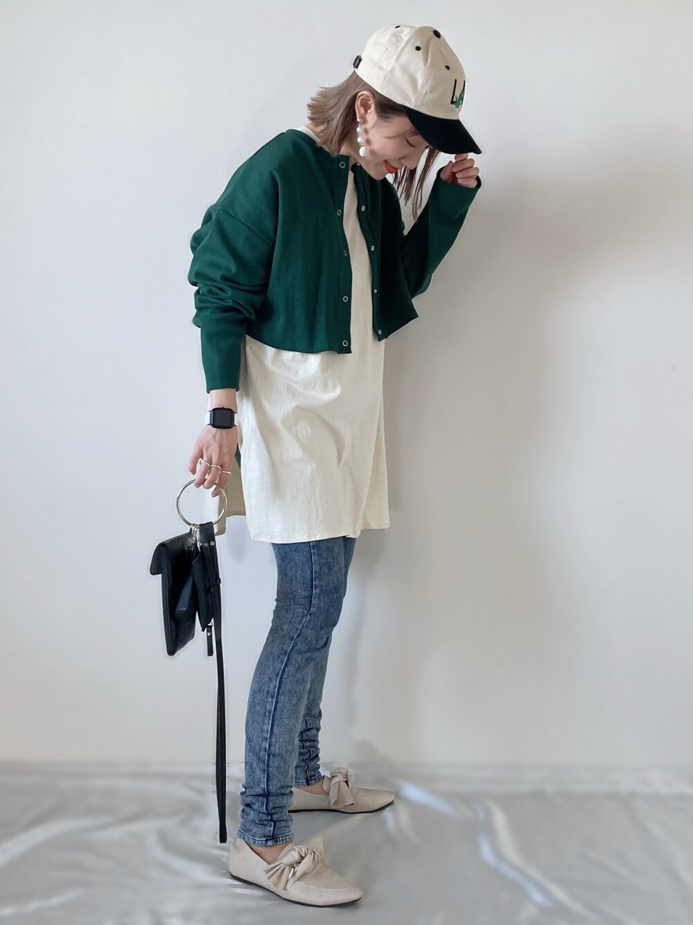 グリーン系のカーディガン/ボレロ、ベージュ系のTシャツ/カットソー、ブラック系のショルダーバッグを着用したレディースの春コーディネートの1枚目の写真