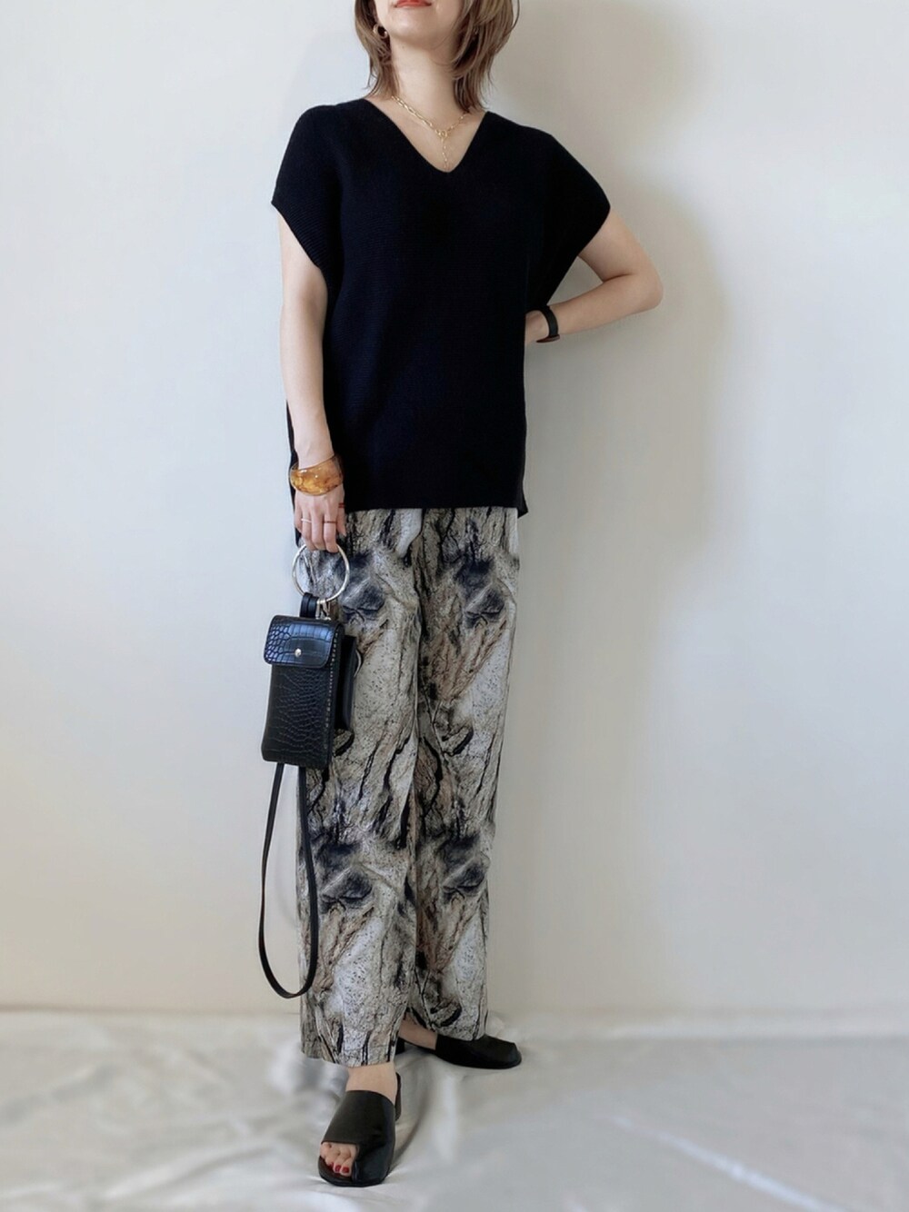 ブラック系のその他パンツ、ブラック系のサンダル、ブラック系のショルダーバッグを着用したレディースの夏コーディネートの1枚目の写真