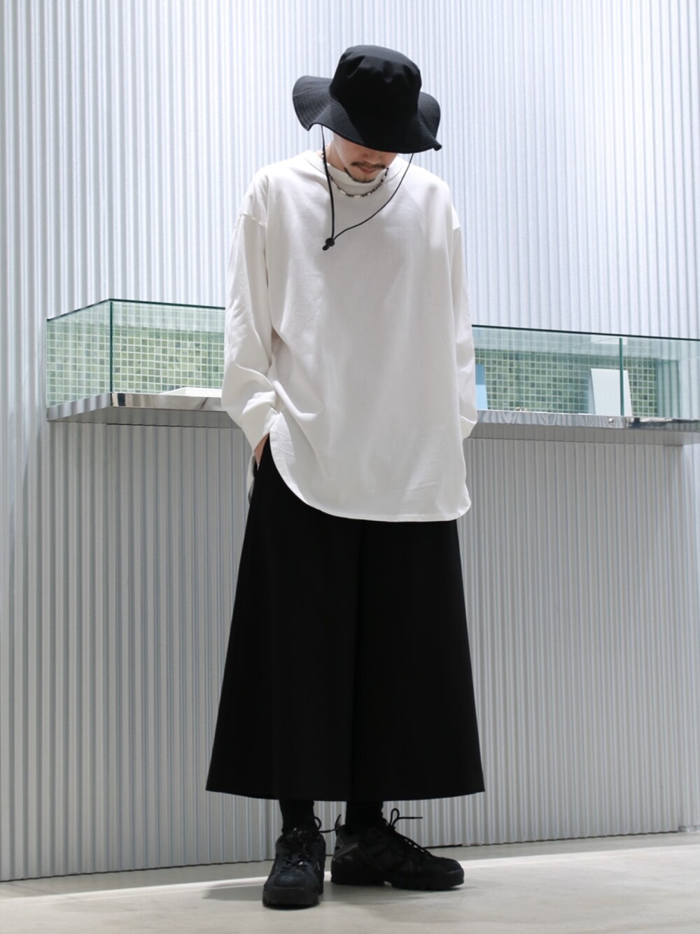 ブラック系のブルゾン、ホワイト系のTシャツ/カットソー、ブラック系のスラックスを着用したメンズの春コーディネートの3枚目の写真