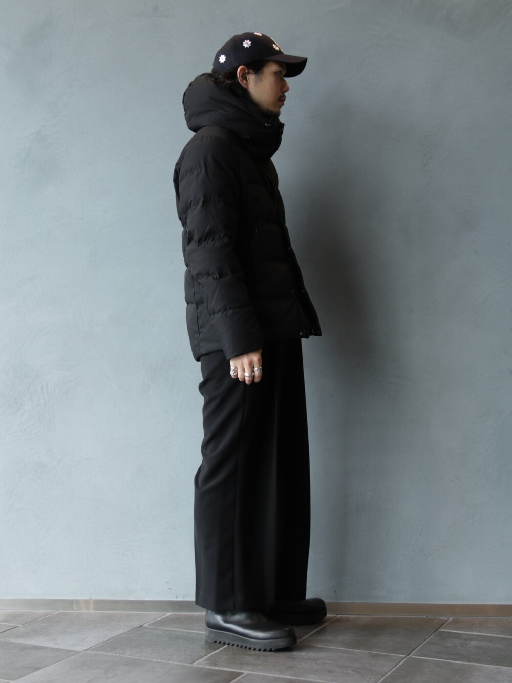 ブラック系のブーツ、ブラック系のスラックス、ブラック系のブルゾンを着用したメンズの冬コーディネートの2枚目の写真