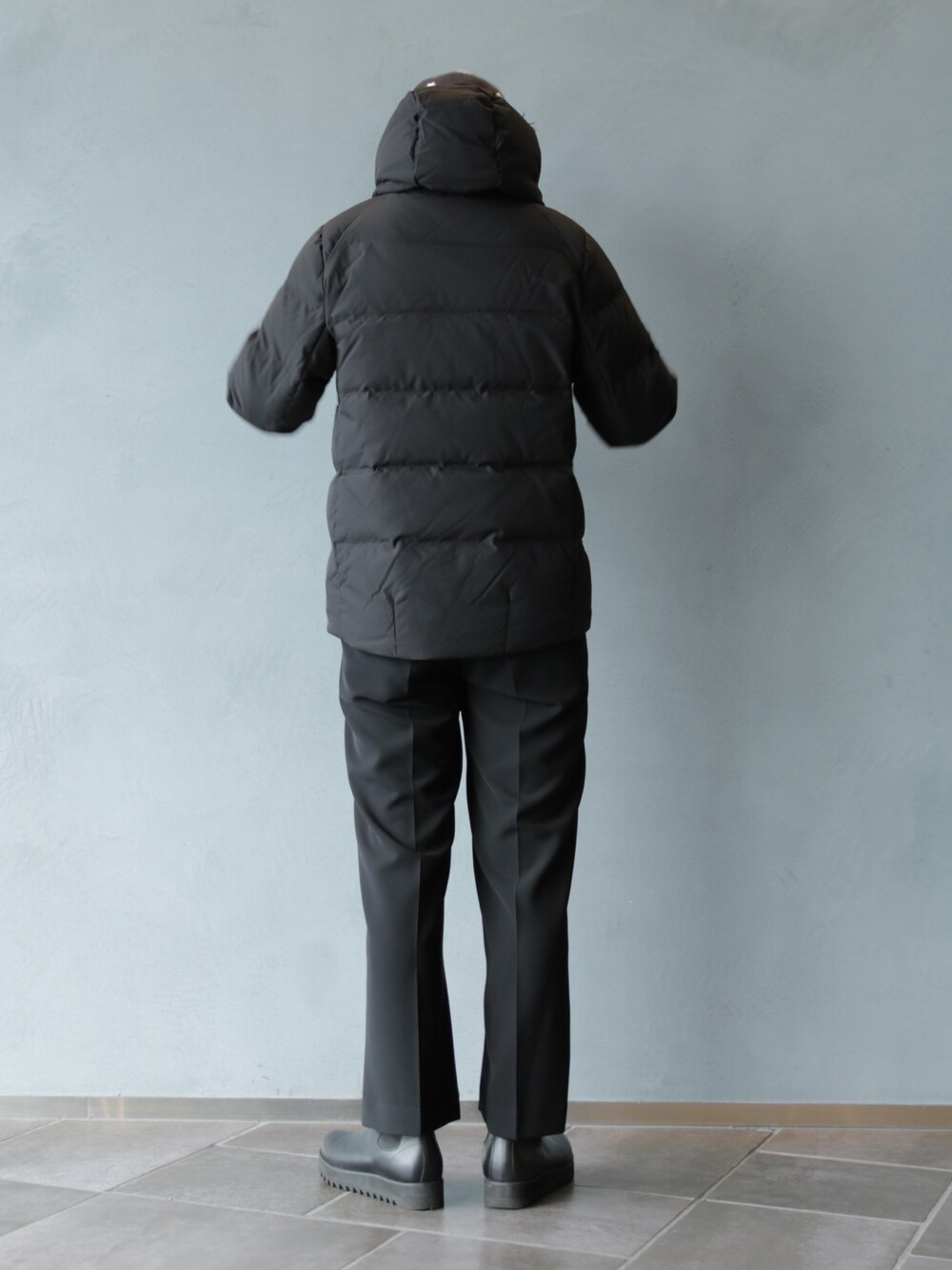 ブラック系のブーツ、ブラック系のスラックス、ブラック系のブルゾンを着用したメンズの冬コーディネートの4枚目の写真