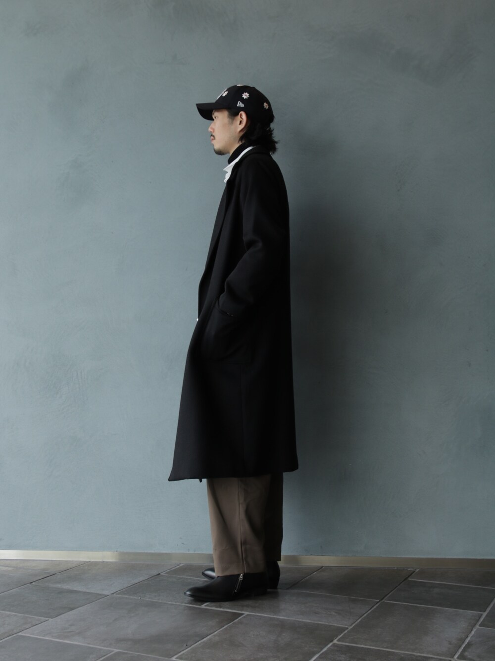 ブラック系のその他シューズ、グレー系のスラックス、ブラック系のその他アウターを着用したメンズの冬コーディネートの2枚目の写真