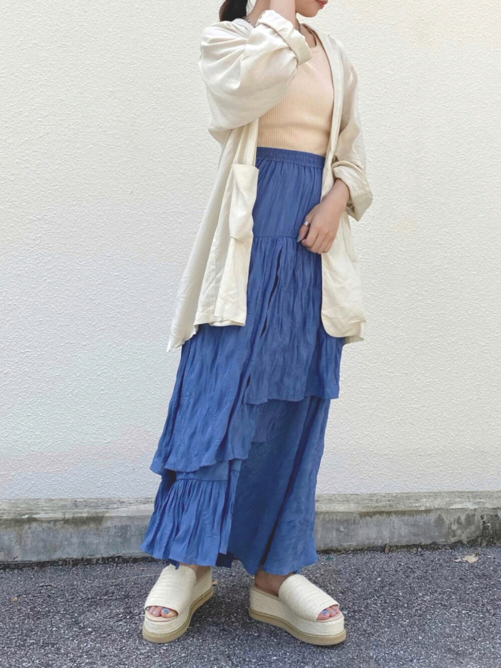 ブルー系のスカート、ホワイト系のタンクトップ、ホワイト系のサンダルを着用したレディースの夏コーディネートの1枚目の写真