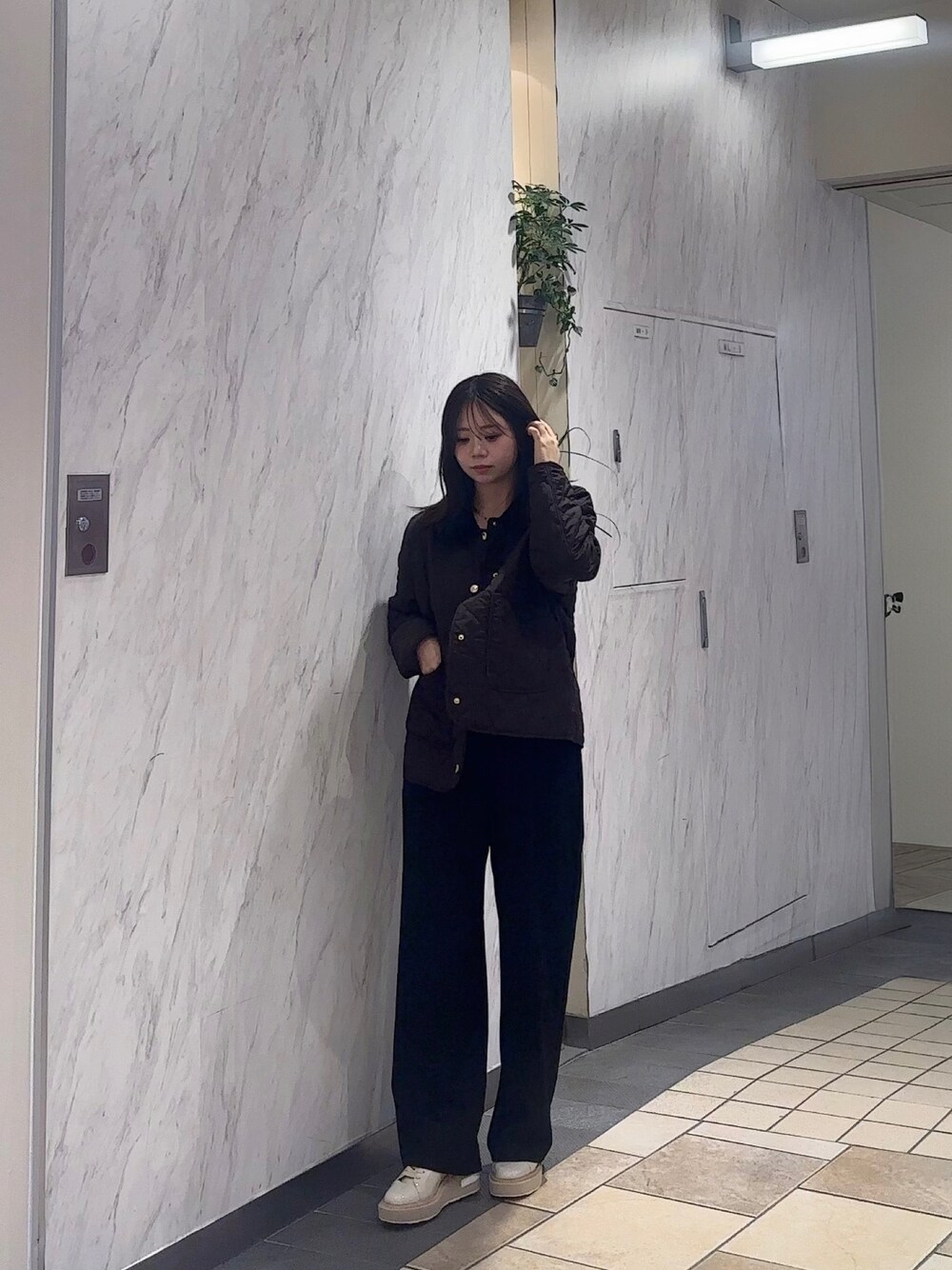 ベージュ系のスニーカー、ブラウン系のジャケット/アウター、ブラック系のスラックスを着用したレディースの秋コーディネートの1枚目の写真